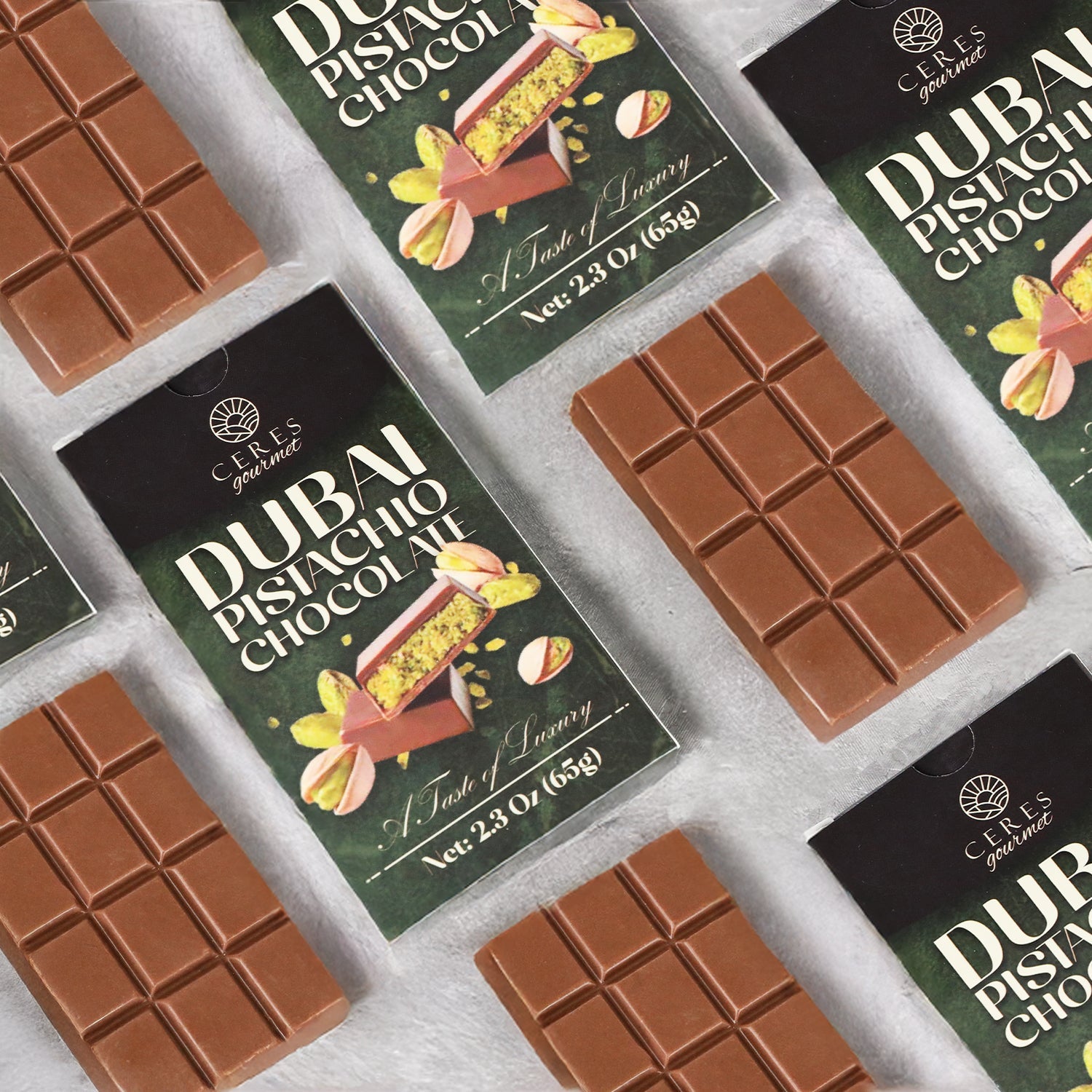 Unwrapped Ceres Gourmet Dubai Chocolate Pistachio Bar – 2.3oz (65g) and its packages, featuring images of rich chocolate with pistachios, are arranged in a flat lay on a light surface.