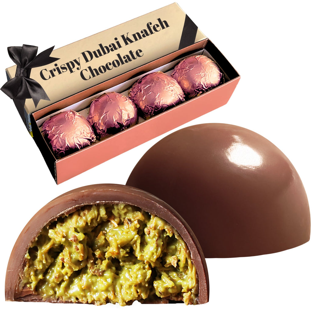 A Ceres Gourmet box labeled Dubai Pistachio Kunafa Chocolate Bite-Size Balls 5.6 Oz shows four pink-wrapped chocolates and two dome-shaped bites—one whole, one cut open to reveal a crispy green pistachio kadayif filling.